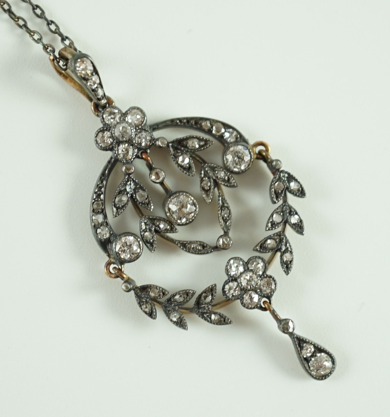 A 19th century gold, silver and diamond cluster set articulated drop pendant